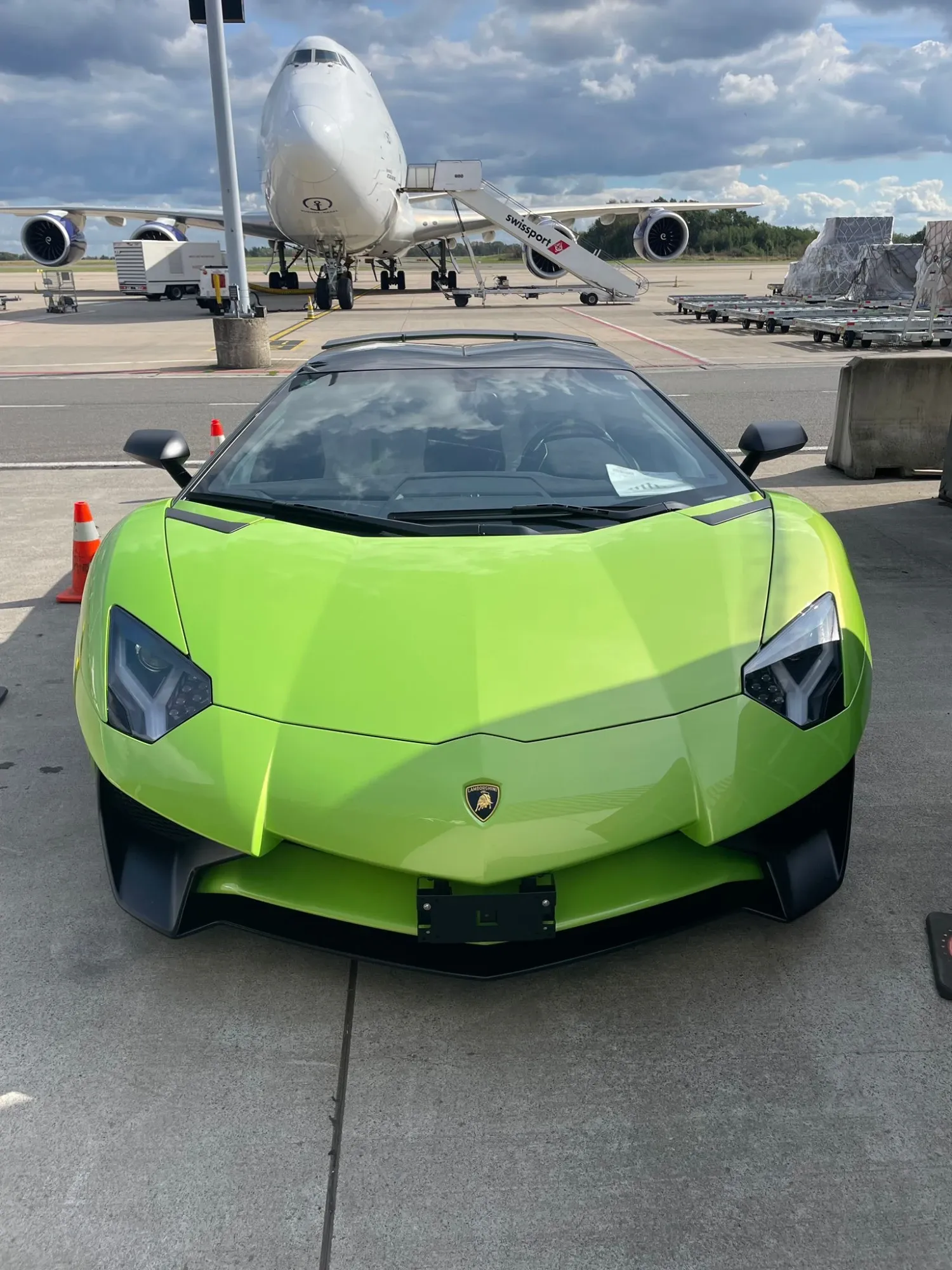 Groene Lamborghini Aventador SV op een luchthavenplatform